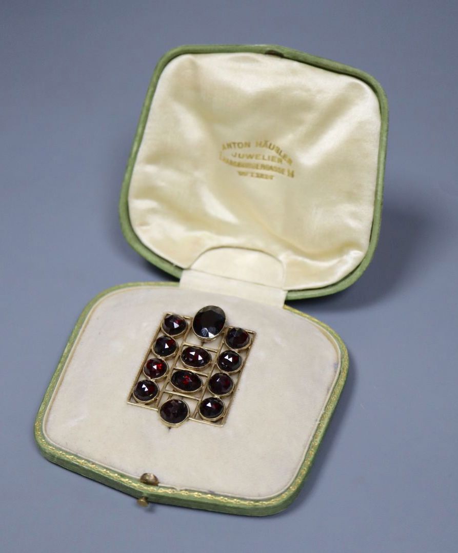 An early 20th century German jugendstil 585 yellow metal and facetted garnet set brooch,